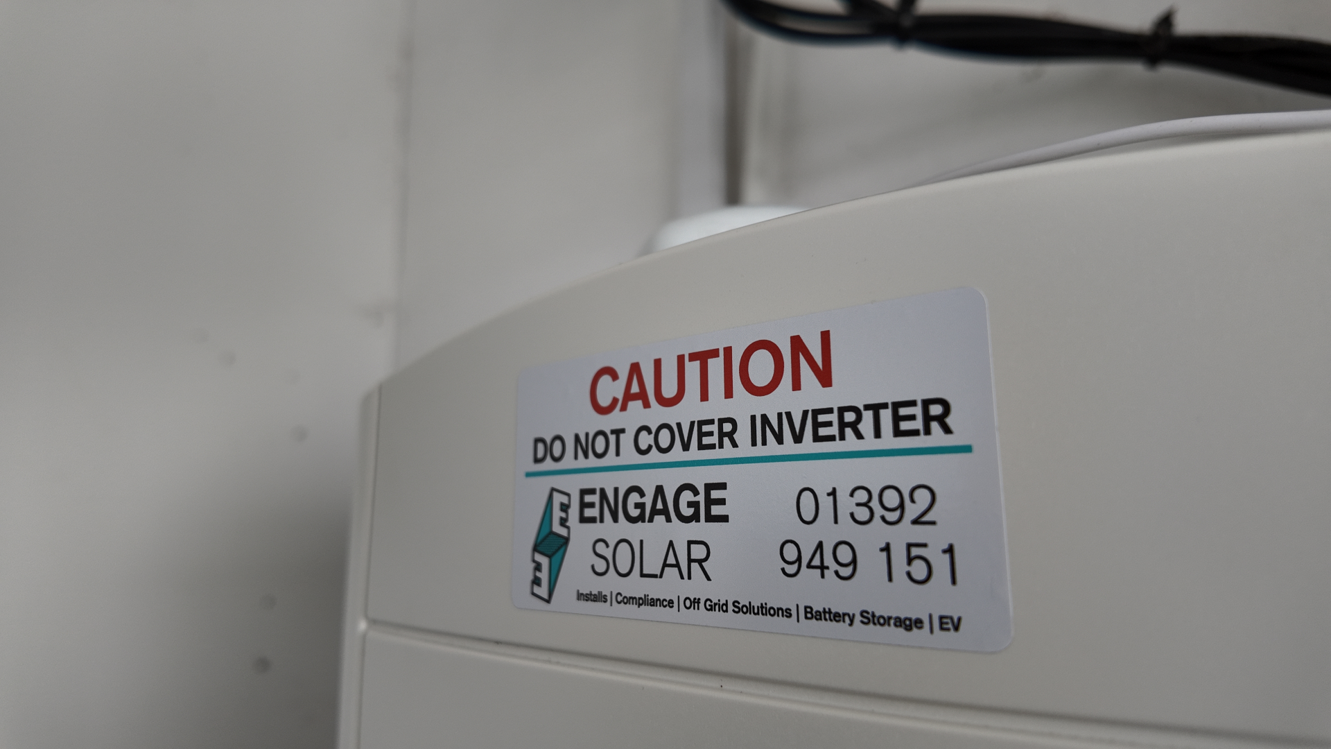 Close-up of a solar inverter safety label on equipment installed in Devon